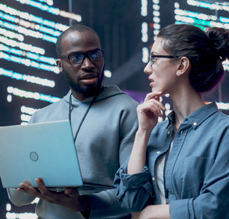 A man and woman are standing in front of a large screen with a laptop. The man is holding the laptop and looking at the screen. AI generated content